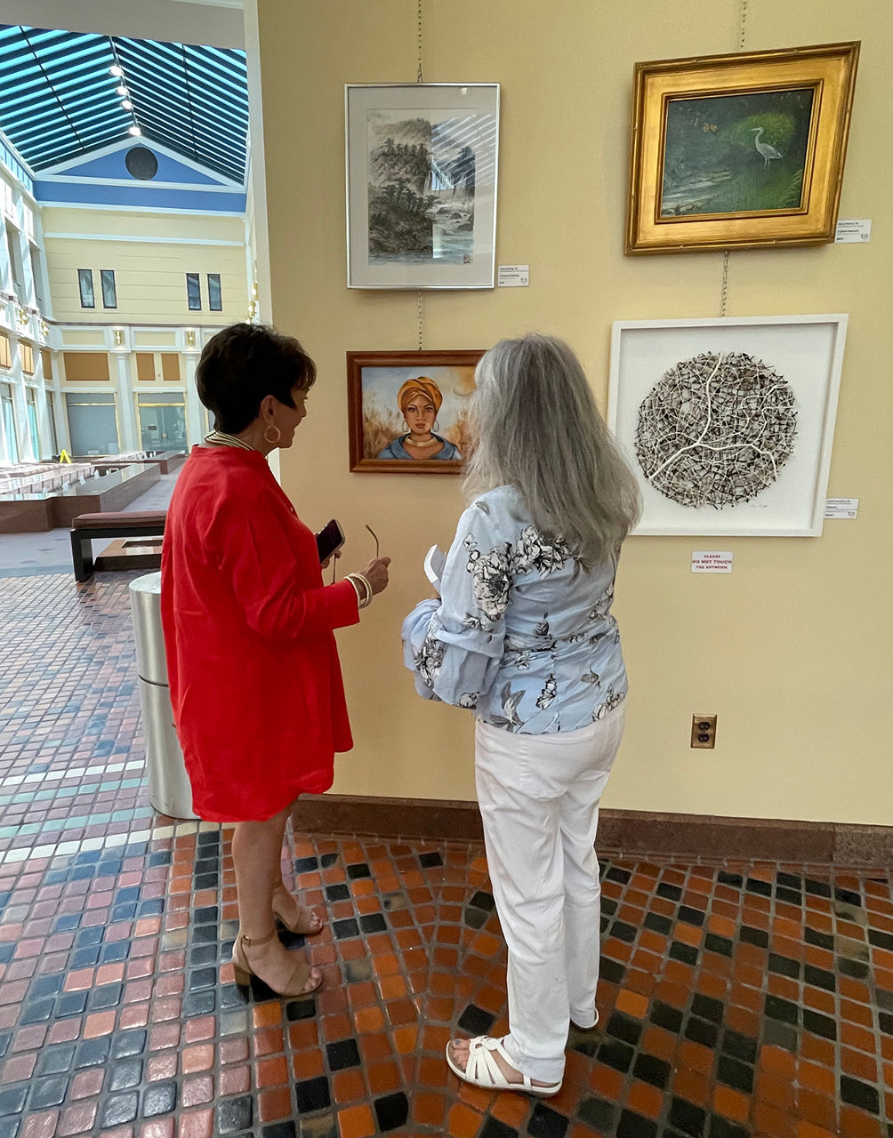 Showcase artist discusses her painting with event attendee at Captiol