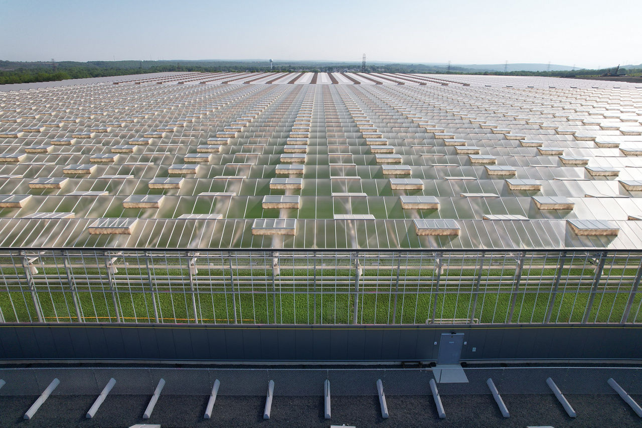 Aerial view of an indoor farm, with plants viewable through the transparent roof