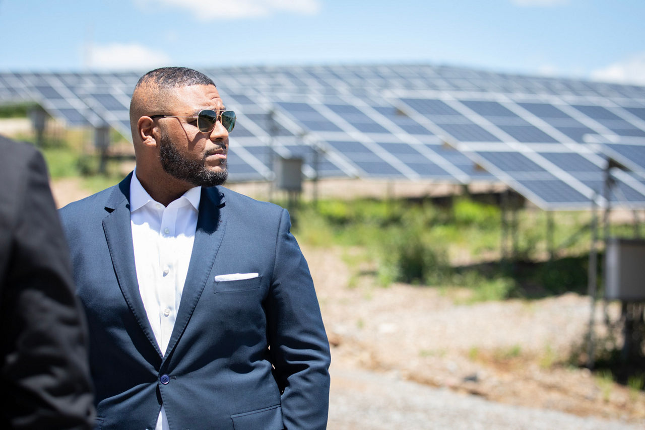 Lieutenant Governor Davis Standing in front of solar panels 