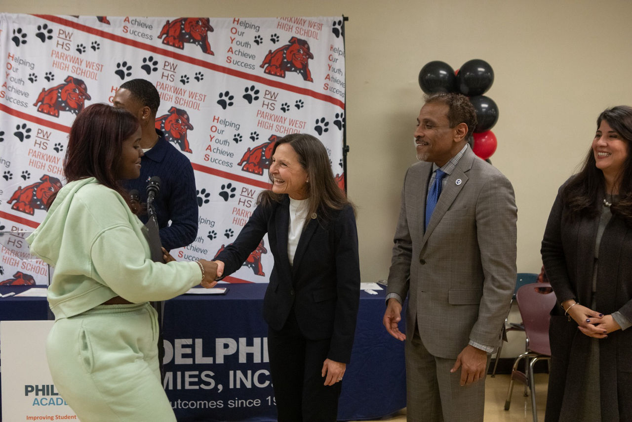 Secretary Nancy A. Walker shakes hand of student receiving Early Childhood Education Pre-Apprenticeship program certificate.