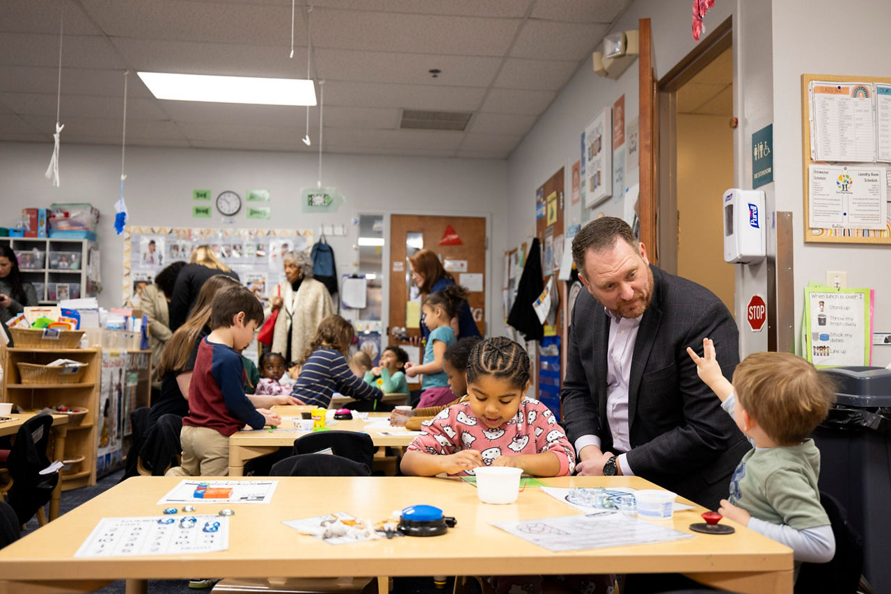 DHS Executive Deputy Secretary Andrew Barnes talks with children at a daycare
