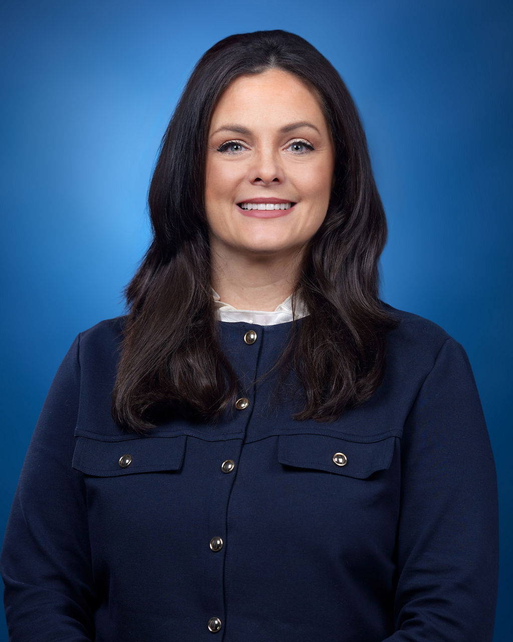 Dr. Stacey Cherny - a woman with long dark hair stands against a blue background