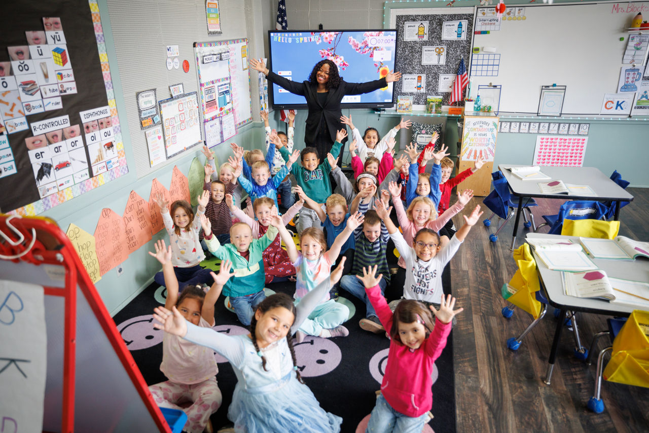 OCDEL Deputy Secretary Shante Brown miles with a call full of children facing the camera
