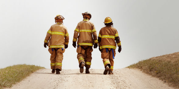 image of three firefighters in gear walking down a dirt road