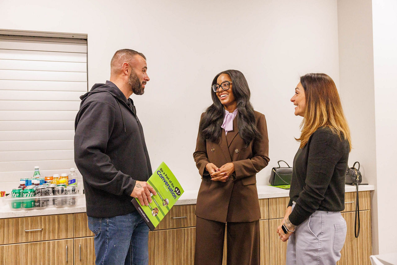 Pennsylvania Department of Drug and Alcohol Programs Secretary Dr. Latika Davis-Jones speaks with a woman in recovery and her husband following the event. The husband holds a folder of Be a Part of the Conversation materials focused on supporting families affected by substance use disorder.