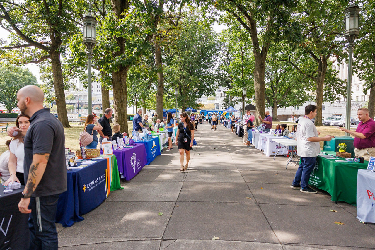 Wide view of the 2026 Recovery in the Grove event at Soldier’s Grove in Harrisburg, with resource tables lining both sides of the main walkway.