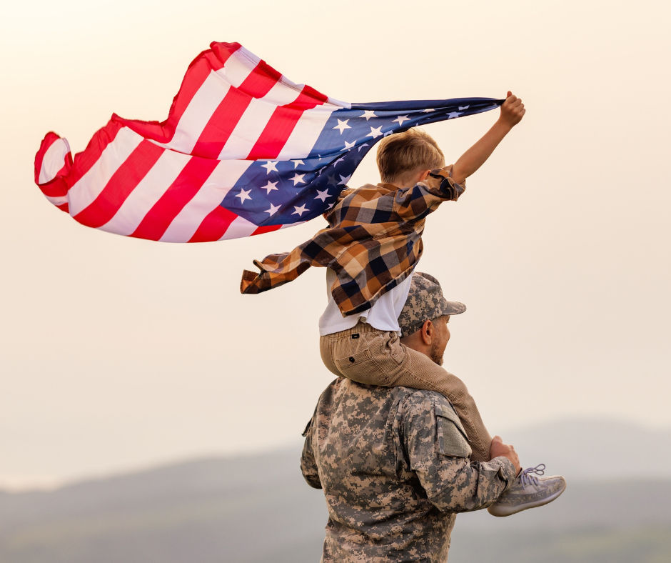 Image a a military man with his son on his shoulders.