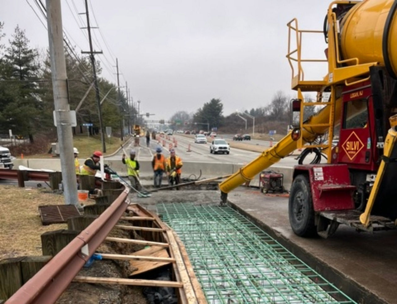 Machine pouring concrete for approach slab extension