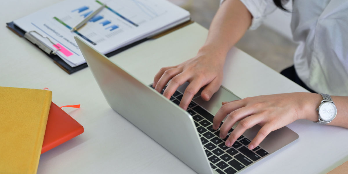 A person working on a laptop with a business plan