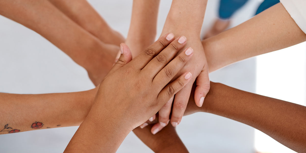A group of people stacking hands on each other