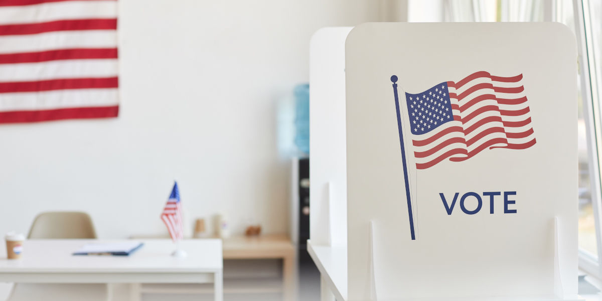 a voting booth with an American flag with the word "Vote"