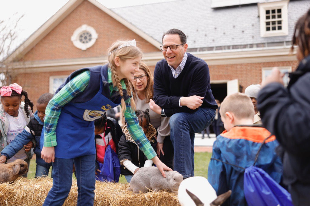Governor Shapiro next to a girl petting a rabbit