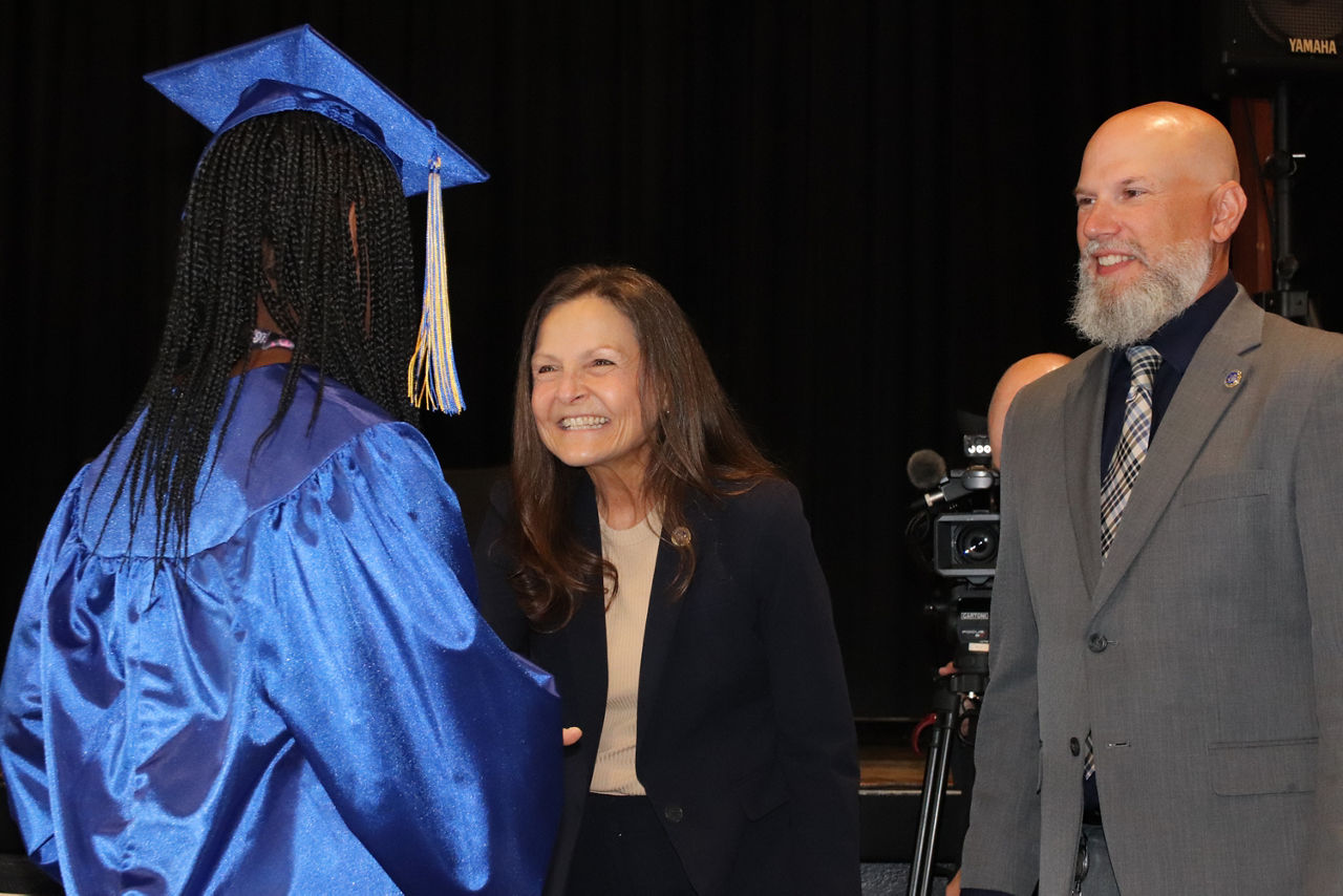 Secretary Nancy A. Walker and OVR Executive Director Ryan Hyde shake hands with a CTI at HGAC summer graduate. 