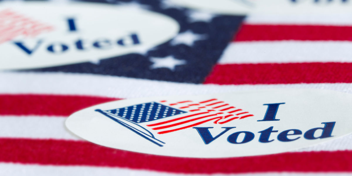 "I voted" stickers laying on an American flag