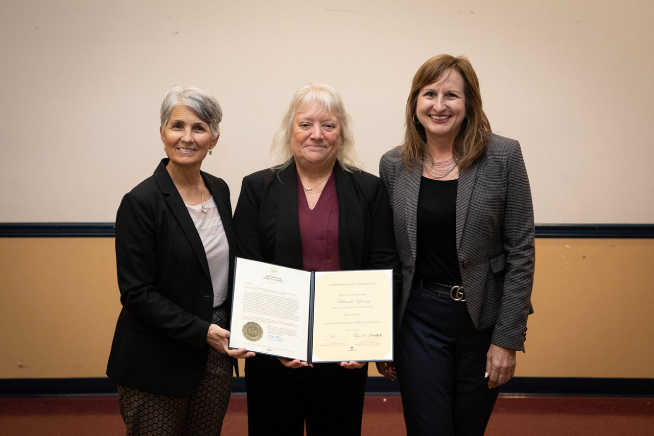 Secretary Spicher and Mary Beth Stringent posing for a photo with Brenda Young and her LDI certificate