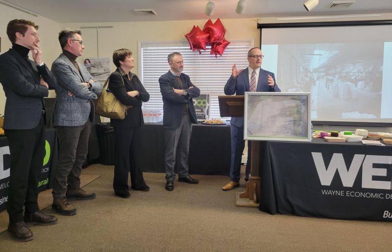 Executives from the company Salaet stand in a conference room at a podium and make an announcement