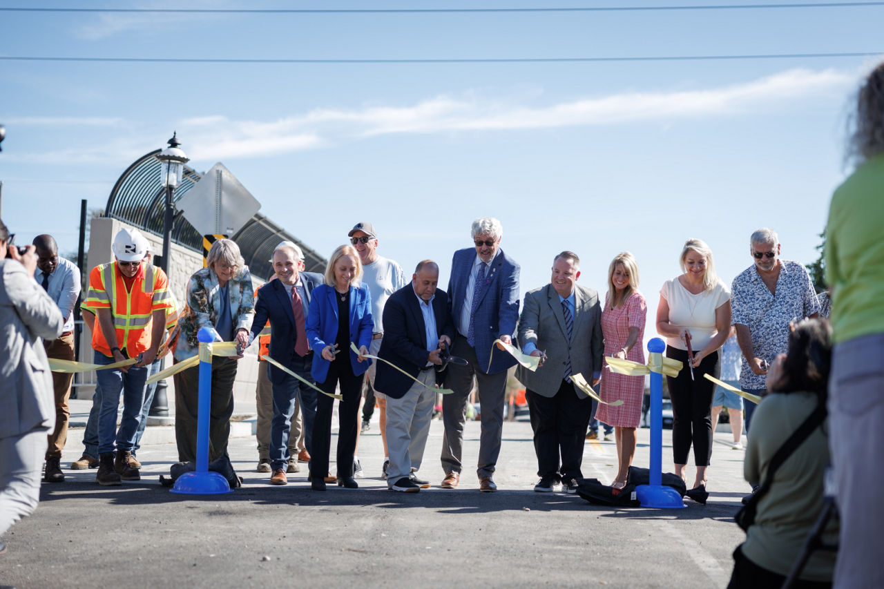 Congresswoman Scanlon, Senator Kearney, Chairperson Reuther, PennDOT Executive Din Abazi, and group cutting the ribbon to reopen Sellers Avenue Bridge