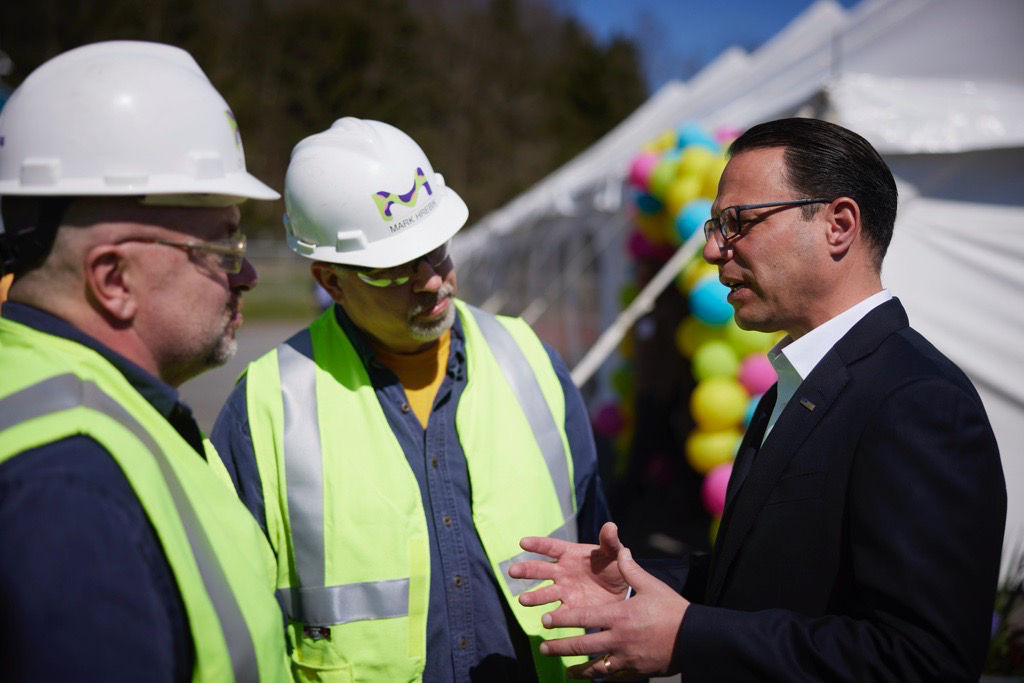 Governor Shapiro speaking with 2 men in hard hats and reflective vests