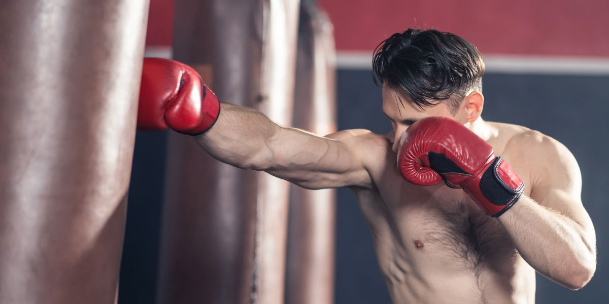 A person wearing boxing gloves hitting a punching bag