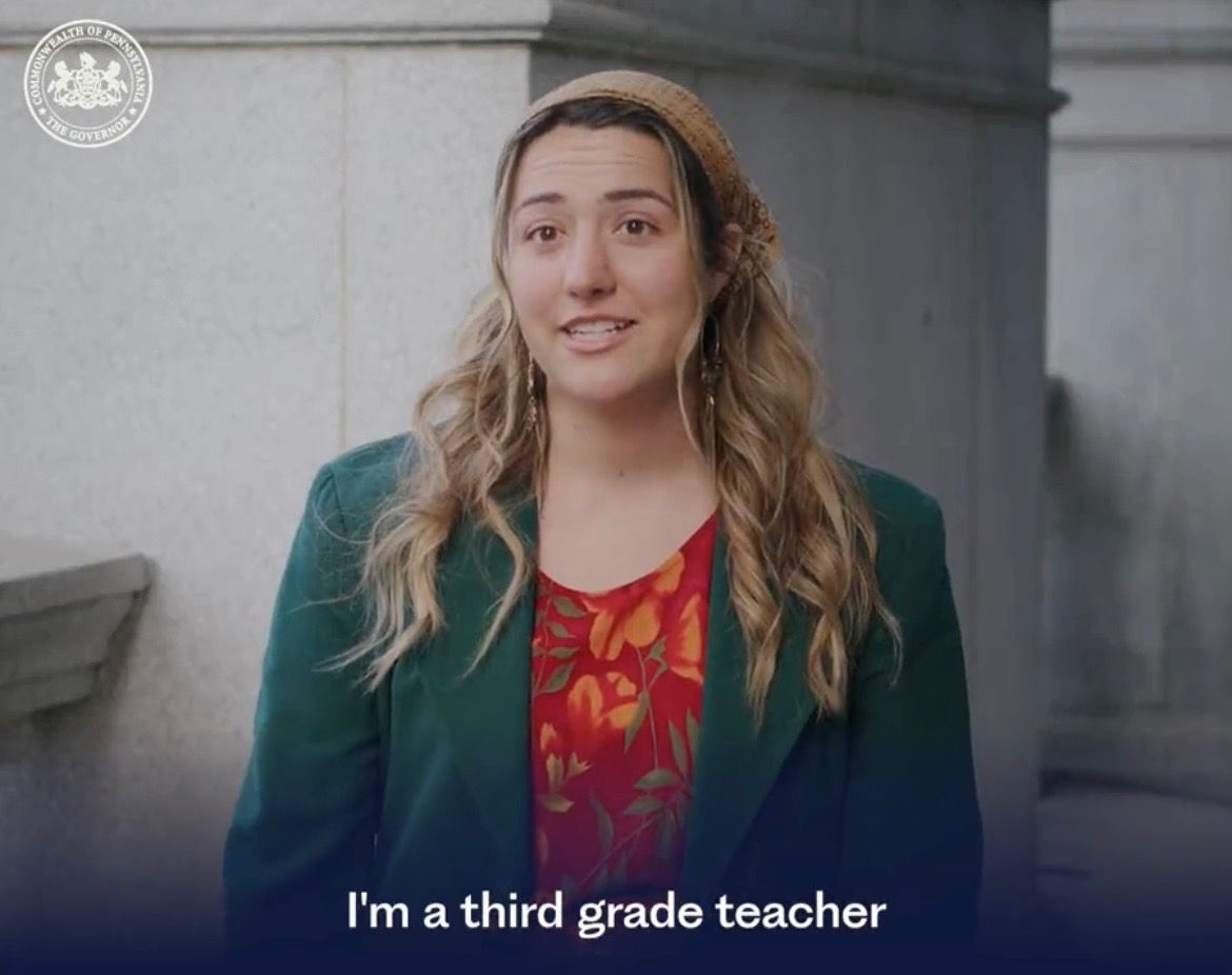 Screenshot of video with woman and the caption says "I'm a third grade teacher"