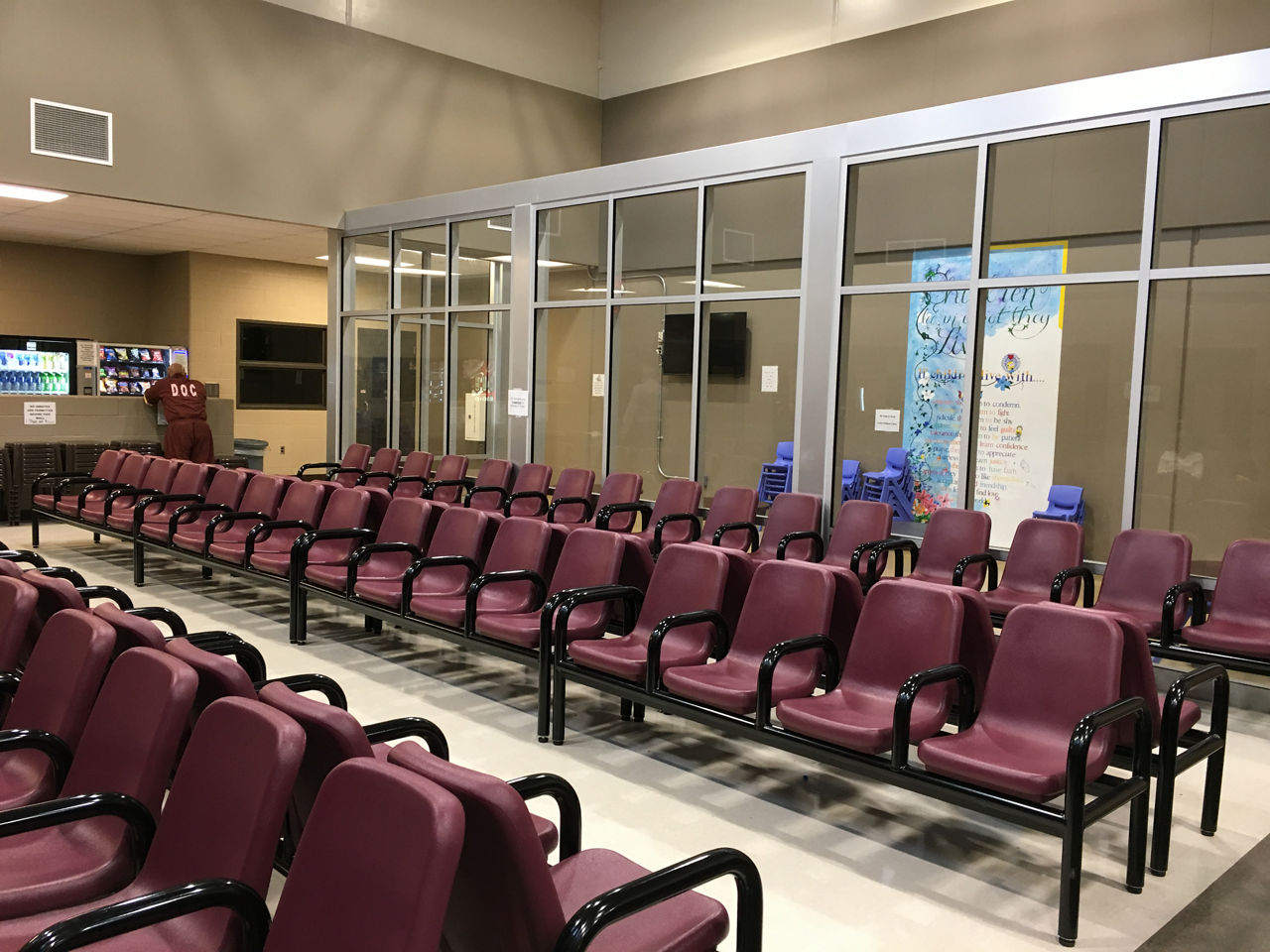 An incarcerated individual stands in an empty visiting room at SCI Phoenix.