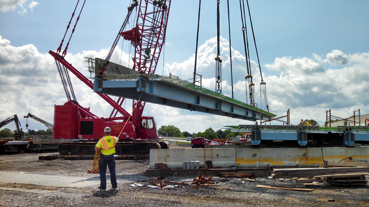 Bridge deck being lifted onto bridge piers. 