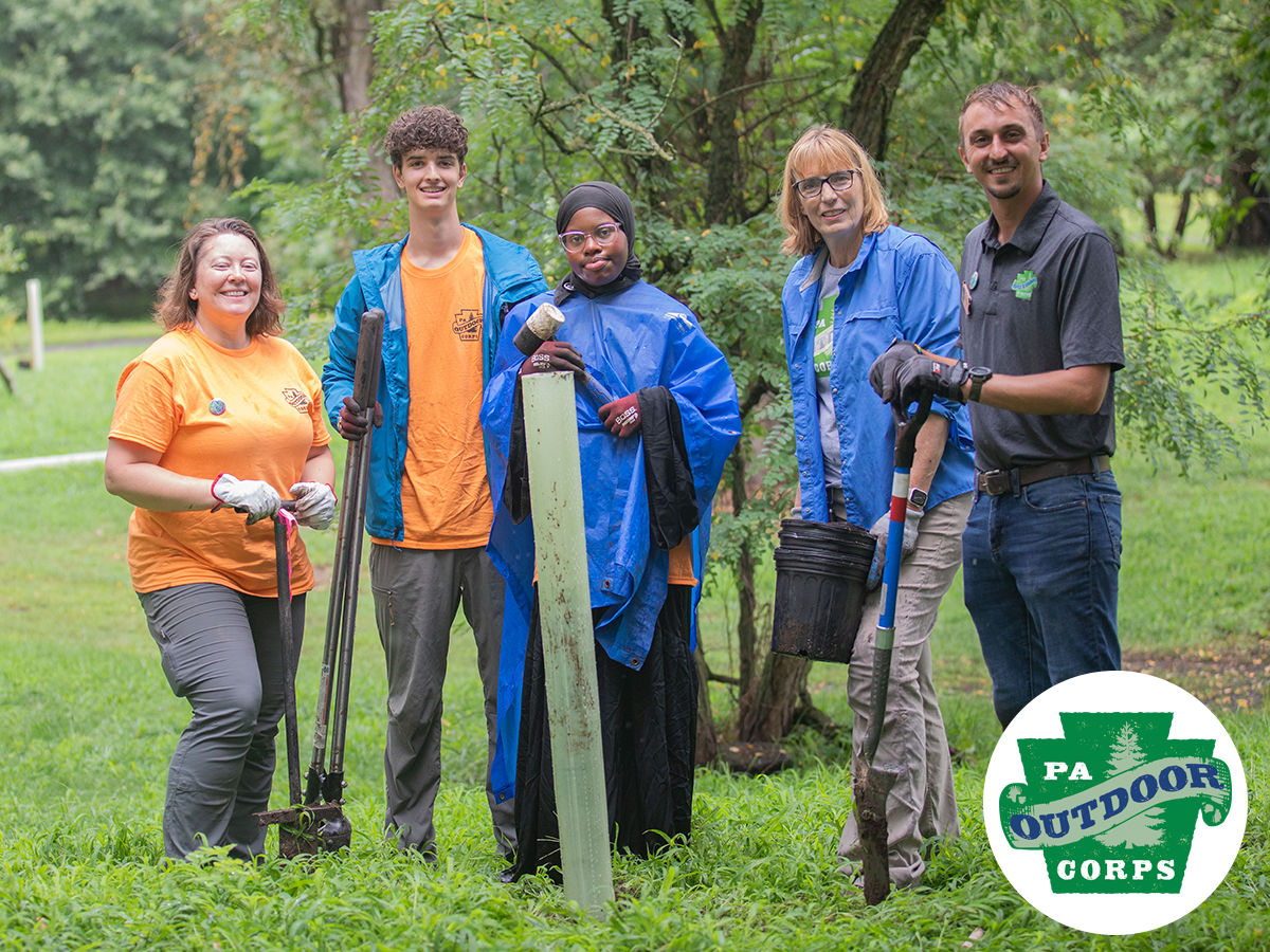 PA Outdoor Corps members and DCNR staff pose for a group photo. The PA Outdoor Corps logo appears in the lower right corner.