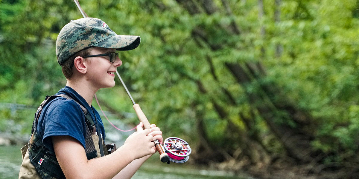 Boy casting a fly fishing rod 