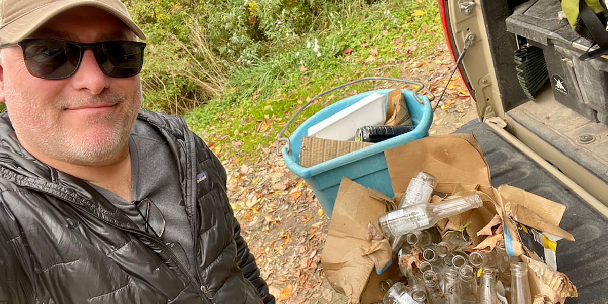 Man in a selfie showing all of the waste he collected while participating in the Adopt an Access Program. Photo courtesy of Backcountry Hunters and Anglers.