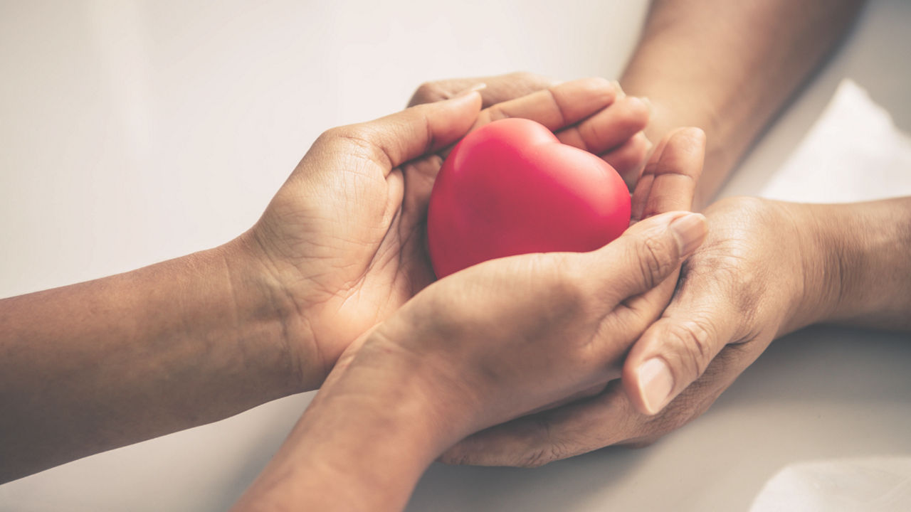 Two people holding a heart