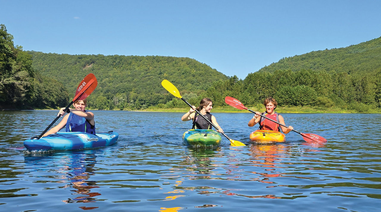 Group of three kayakers wearing life jackets and enjoying a paddle on the Allegheny River.