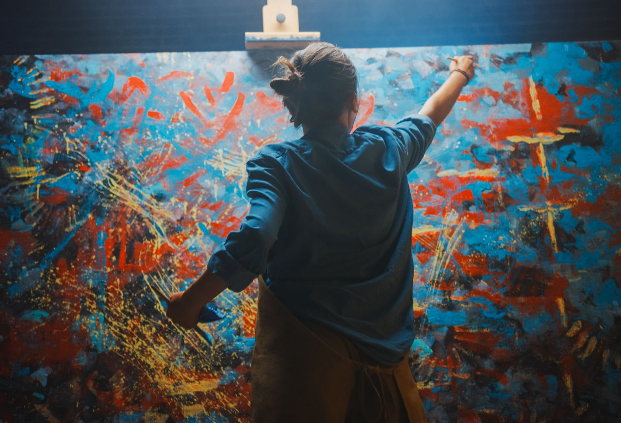 Artist using paintbrush to paint on canvas