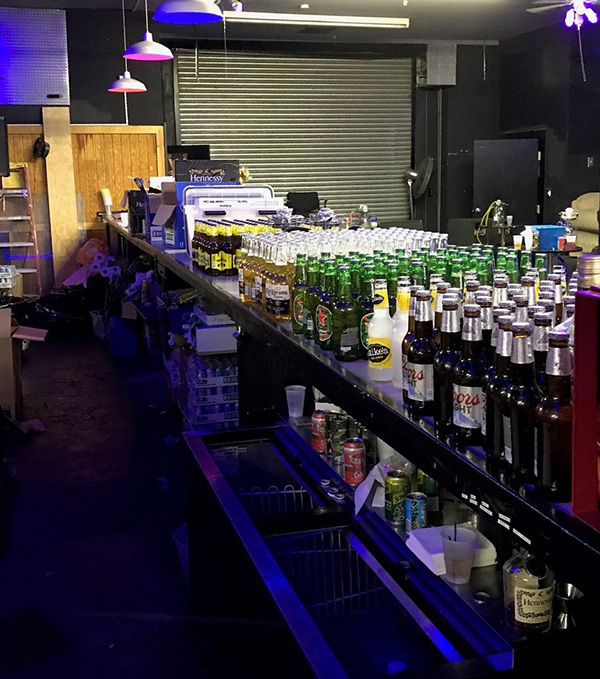 a speakeasy with bottles of alcohol on the bar