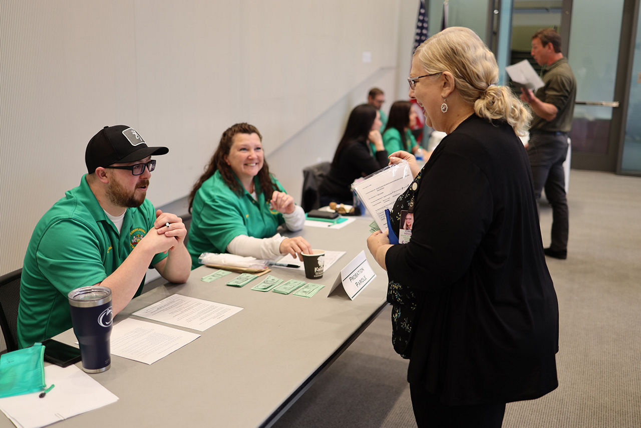 Bureau of Reentry Coordination employees speak to a participant in a reentry simulation