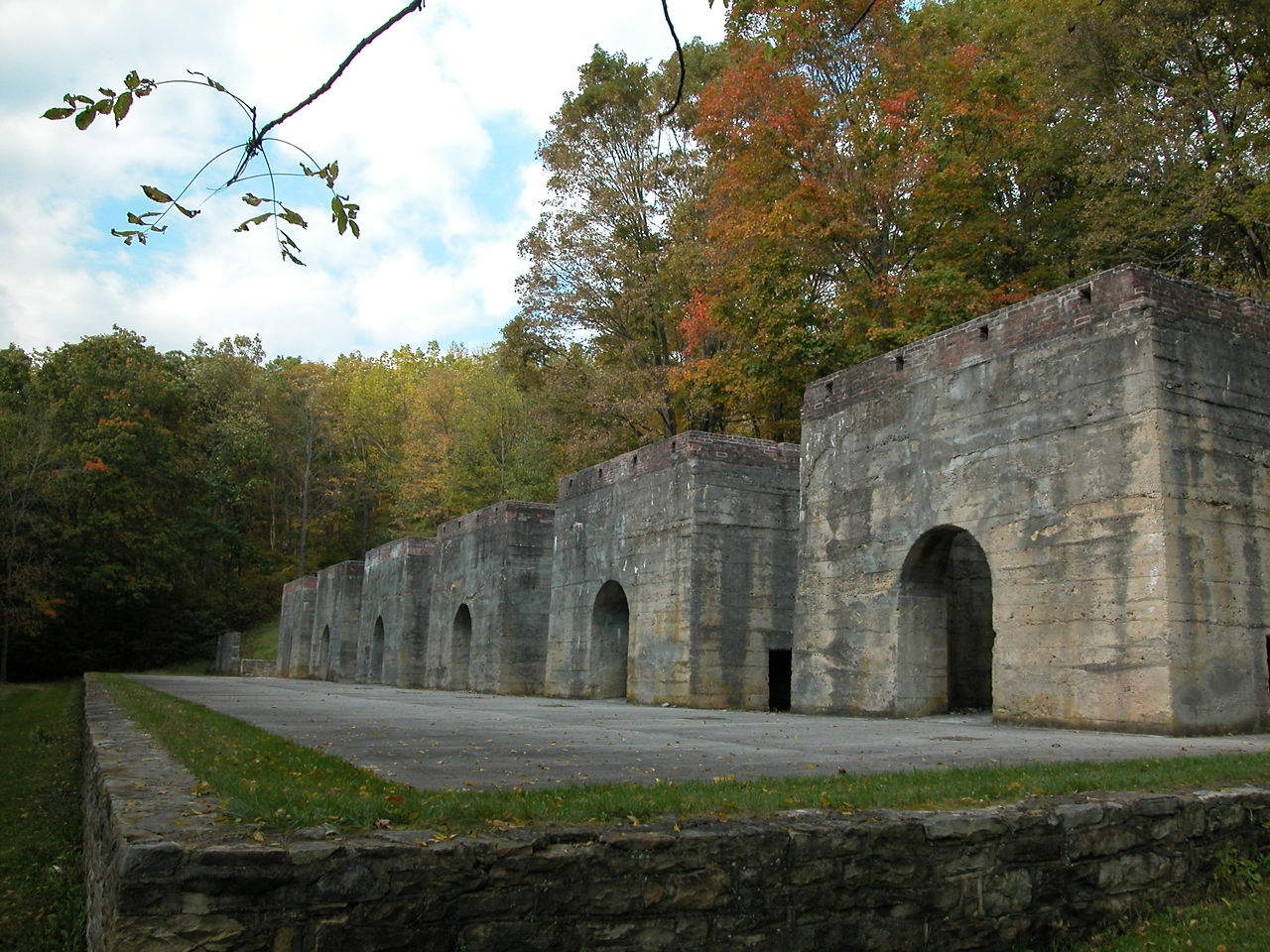 A row of historic stone limestone kilns on a fall day