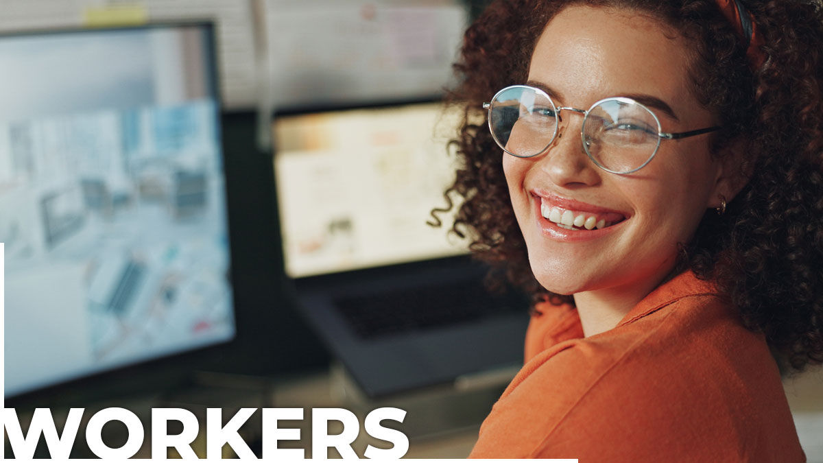 A young professional woman sitting in front of a computer and smiling. The word "Workers" is in the bottom left corner of the image.