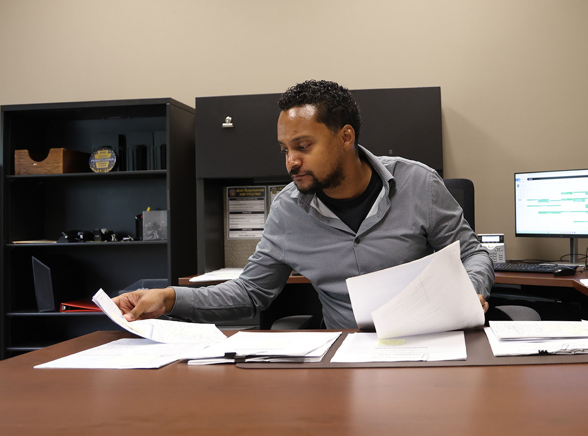 PFBC licensing employee organizing papers on his desk.