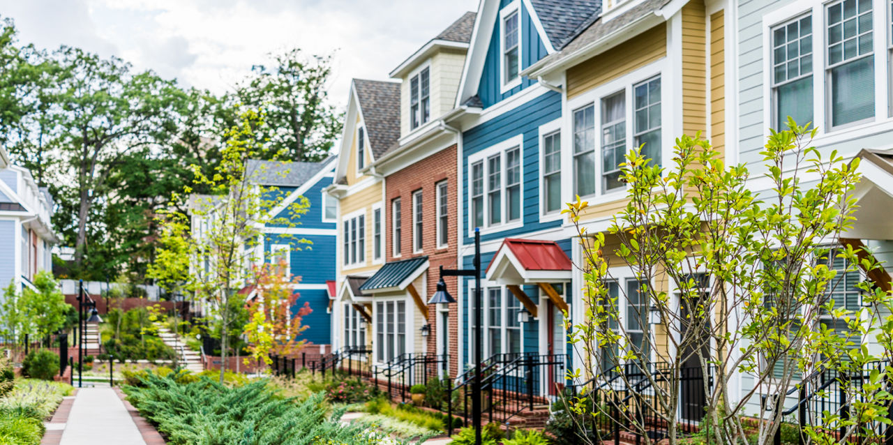 A charming row of colorful townhomes in white, yellow, red, and blue.