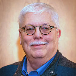 Bob Kirchner smiles wearing blue shirt and jacket