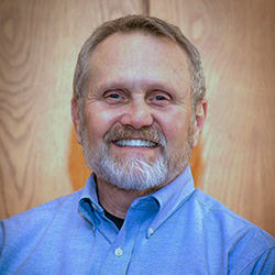 Gary Kribbs smiles wearing blue shirt