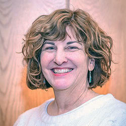 Janet Sweeny smiles wearing cream colored sweater