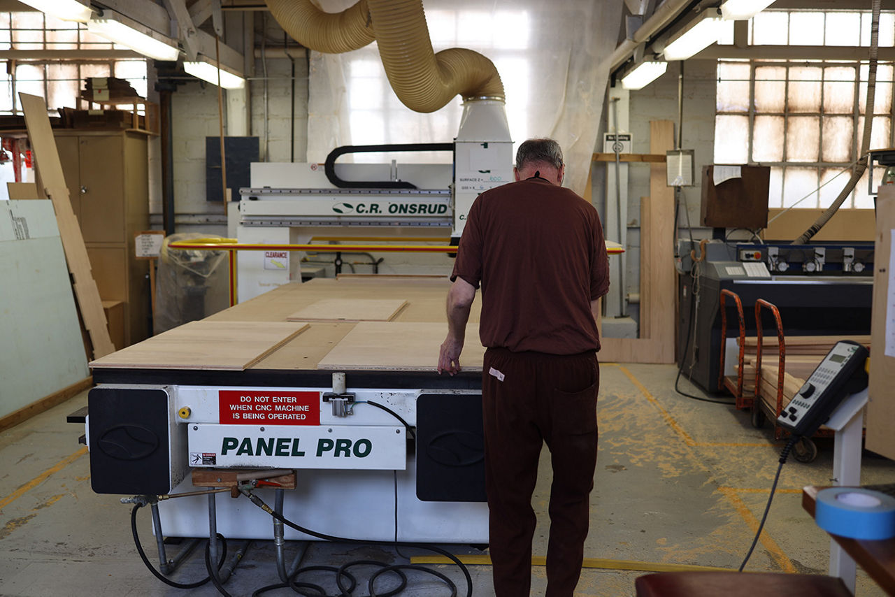 An inmate using a machine for woodworking