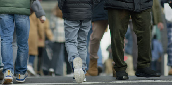 Feet walking along a busy street.