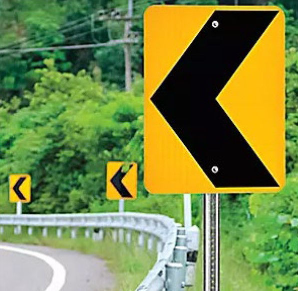 Photo of road with yellow/black curve signs for reference