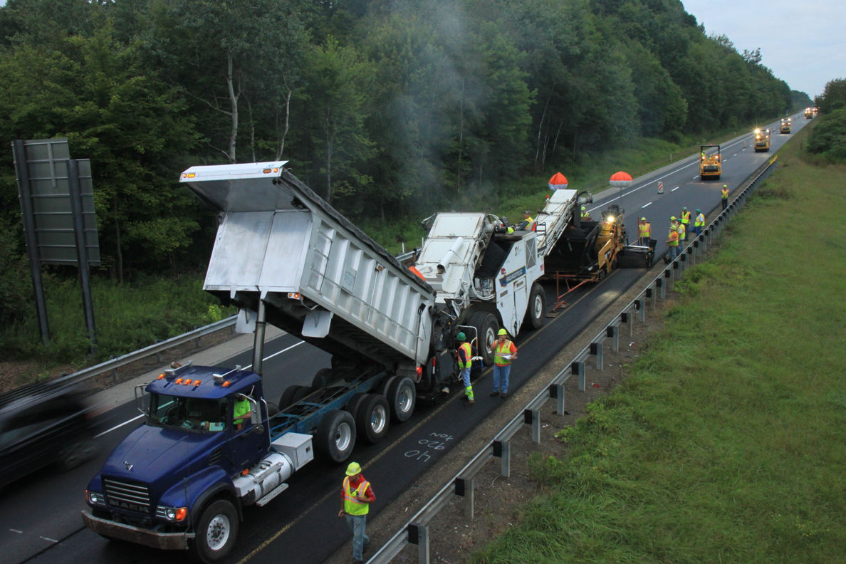 Active pavement construction crew working on pavement.