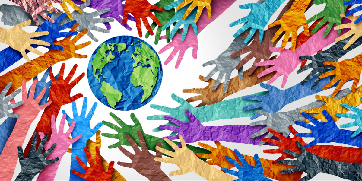 outstretched hands of all colors reaching toward the globe