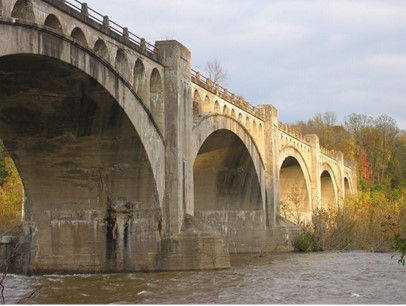 A concrete arched bridge over a river.