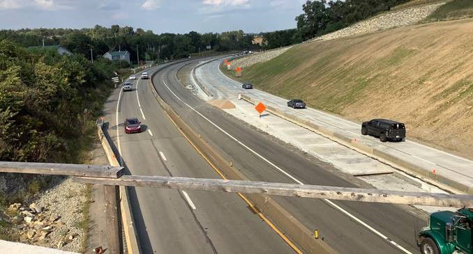 Cars driving through a construction zone on a highway.