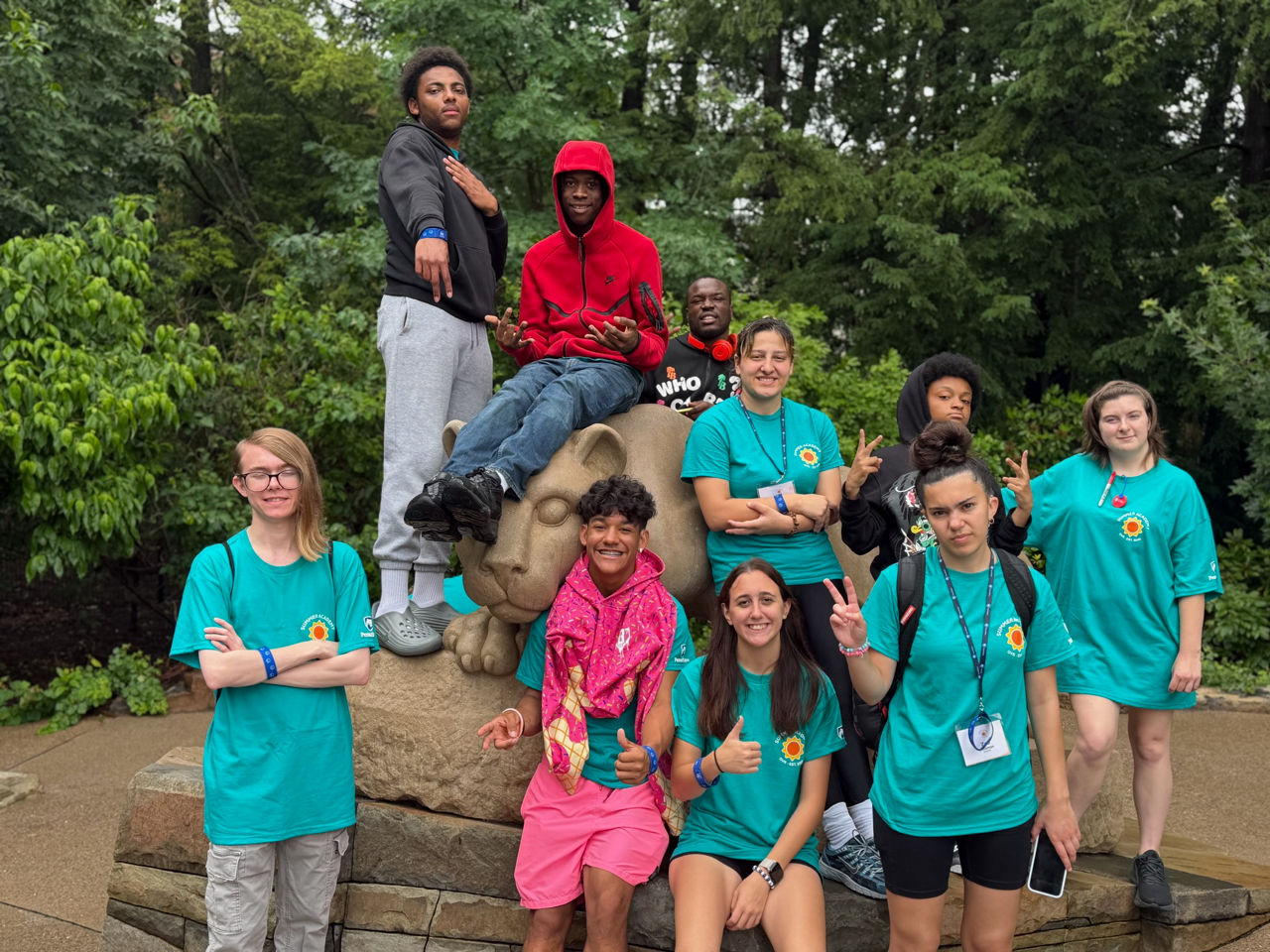 Deaf and Hard of Hearing Summer Academy pose for a group photo at the Nittany Lion statue at Penn State University Main campus.