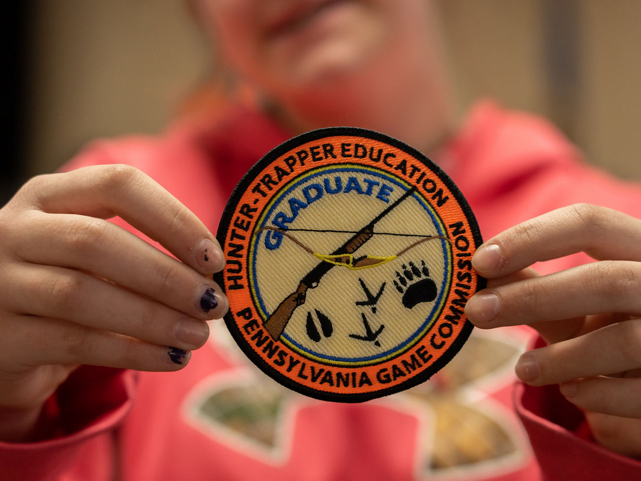 Hunter holding up a hunter trapper education patch